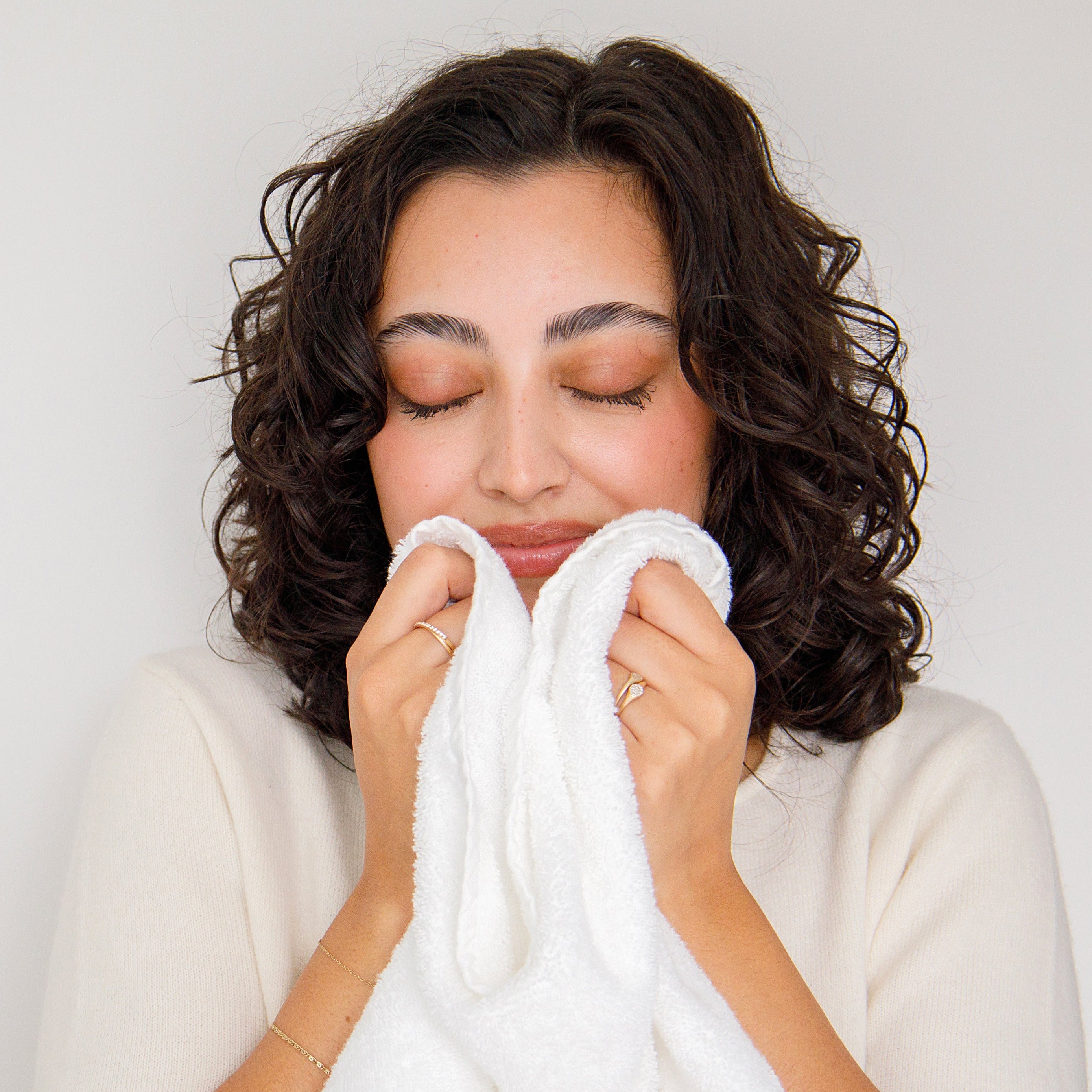 vrouw die aan handdoeken ruikt