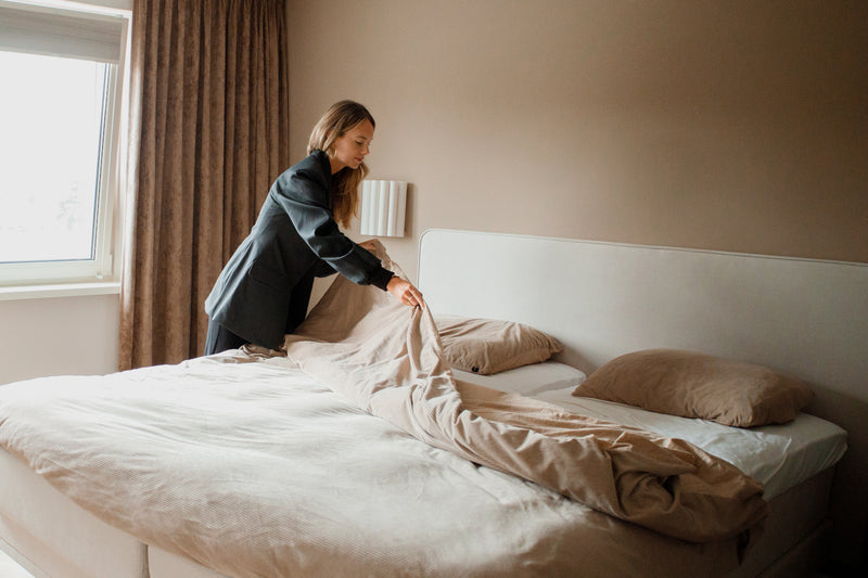 vrouw die bed opmaakt